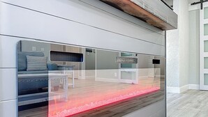 Een moderne kamer met een grote glazen wand, een houten vloer en een ingebouwde bank met kussen.
