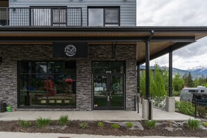 Ein modernes Gebäude mit einer Stein-Fassade, großen Fenstern und einem Schild für Revvystock Brewing Co.