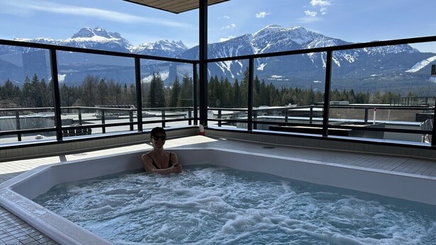 Eine Person in einer Hot Tub mit Blick auf die Berge.