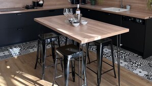 A modern kitchen with a central island, pendant lighting, and a dining area with stools. - Large Provençal-style family home with swimming pool in a quiet location (Saint-Maximin-la-Sainte-Baume)