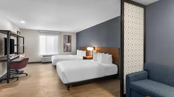 Een hotelkamer met twee bedden, een bureau, een stoel, een bank en een decoratief wandpaneel.