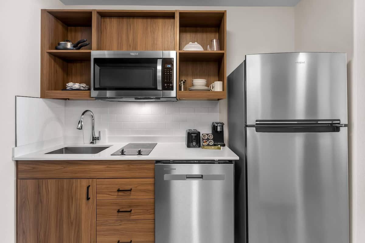 A modern kitchen with a stainless steel microwave, refrigerator, and dishwasher.
