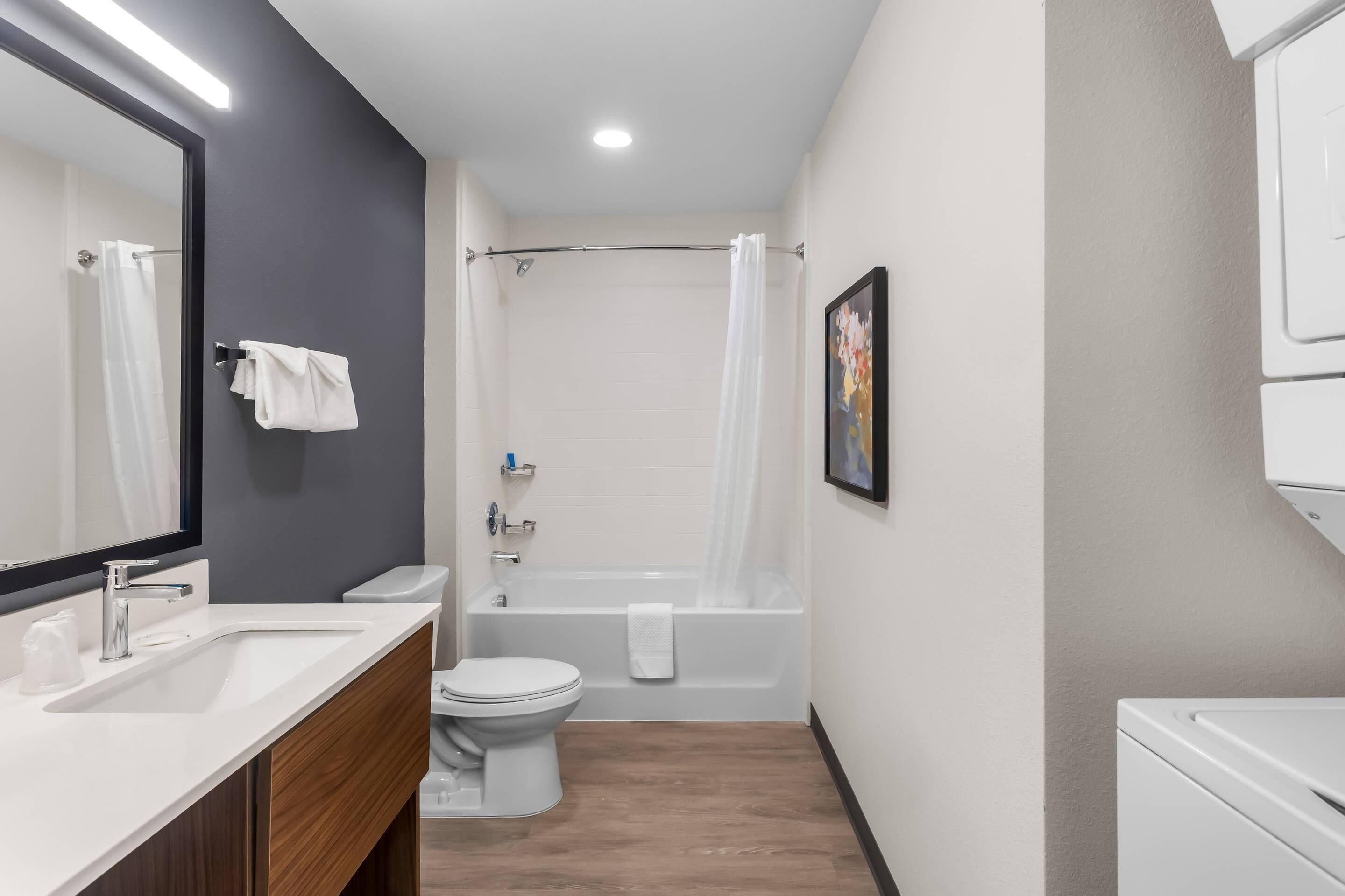 Un baño moderno con lavamanos, inodoro y bañera blancos.