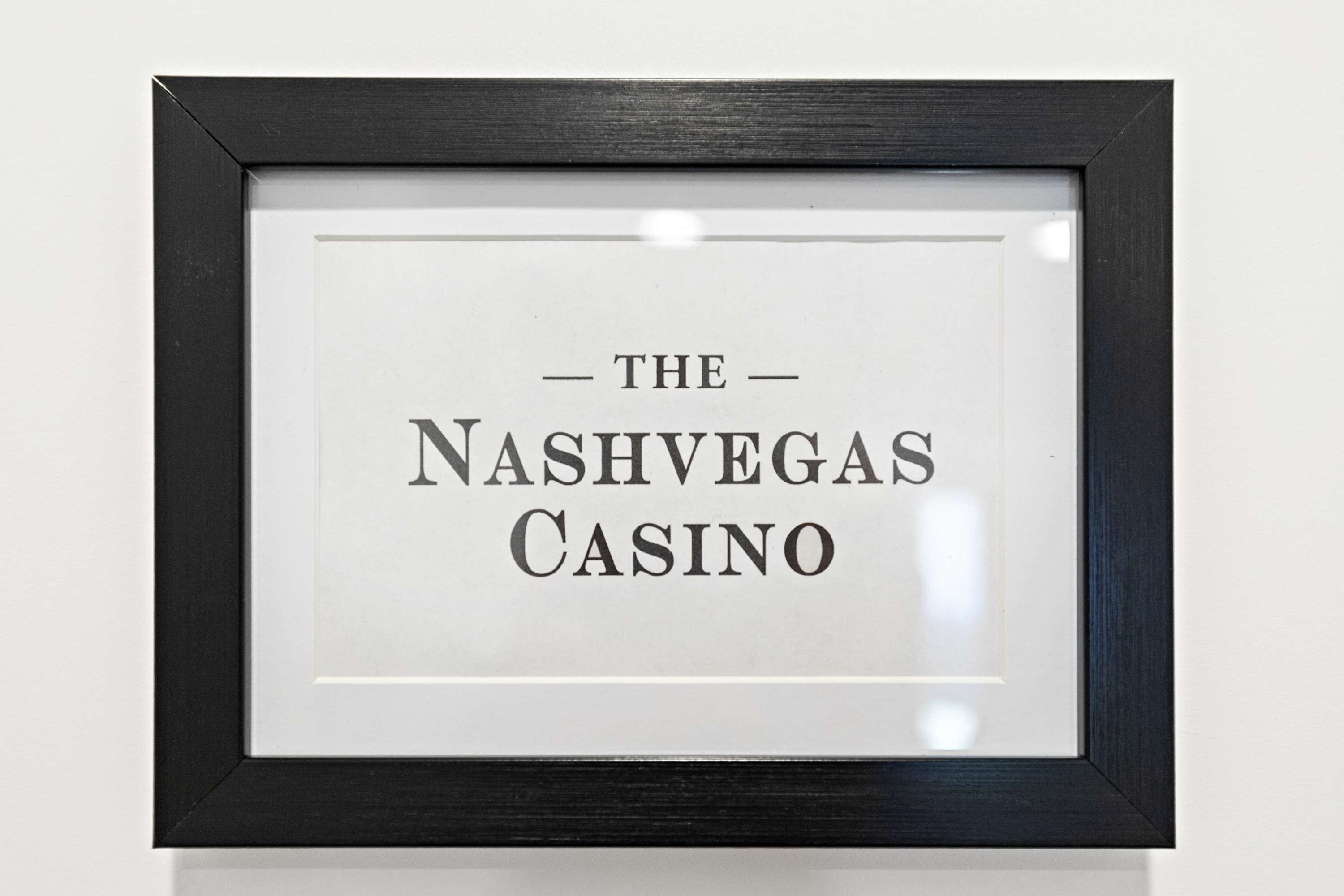 Egy keretbe foglalt tábla, amelyen a következő felirat szerepel: „THE NASHVEGA CASINO”.