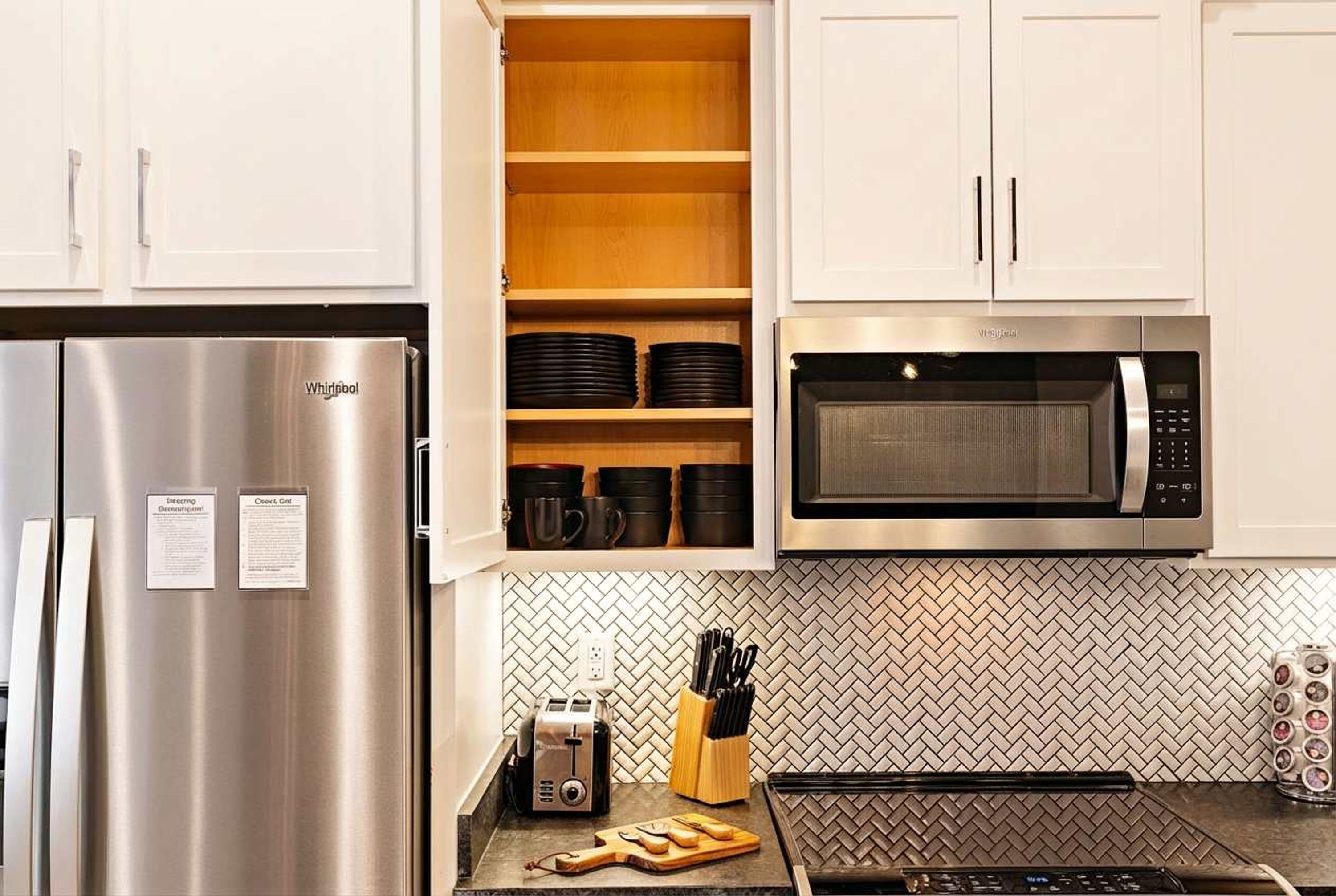 Eine Küche mit einem Edelstahl-Kühlschrank von Whirlpool, einer Mikrowelle und einem Toaster.