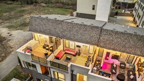 Un immeuble à plusieurs étages doté d’une terrasse sur le toit, de grandes fenêtres et d’un style architectural moderne.