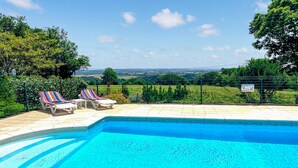 A swimming pool with two lounge chairs and a view of the countryside. - 3 bedroom amazing home in Jouqueviel (Jouqueviel)