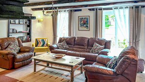 A living room with leather sofas, a coffee table, and a bookshelf. - 3 bedroom amazing home in Jouqueviel (Jouqueviel)