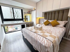 Ein Schlafzimmer mit einem Bett, einem Nachttisch und einem Schreibtisch mit Stuhl.