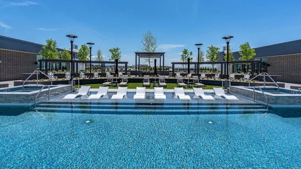 A modern outdoor pool area with multiple lounge chairs and a central seating area. - Views! Amenities! Pool/Spa/Gym/Bowl/Pking! (Salt Lake City)