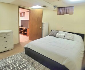 A bedroom with a bed, a dresser, a wardrobe, and a television in the corner. - Lovely 3-bedroom house with AC in Saint Paul Park (Saint Paul Park)