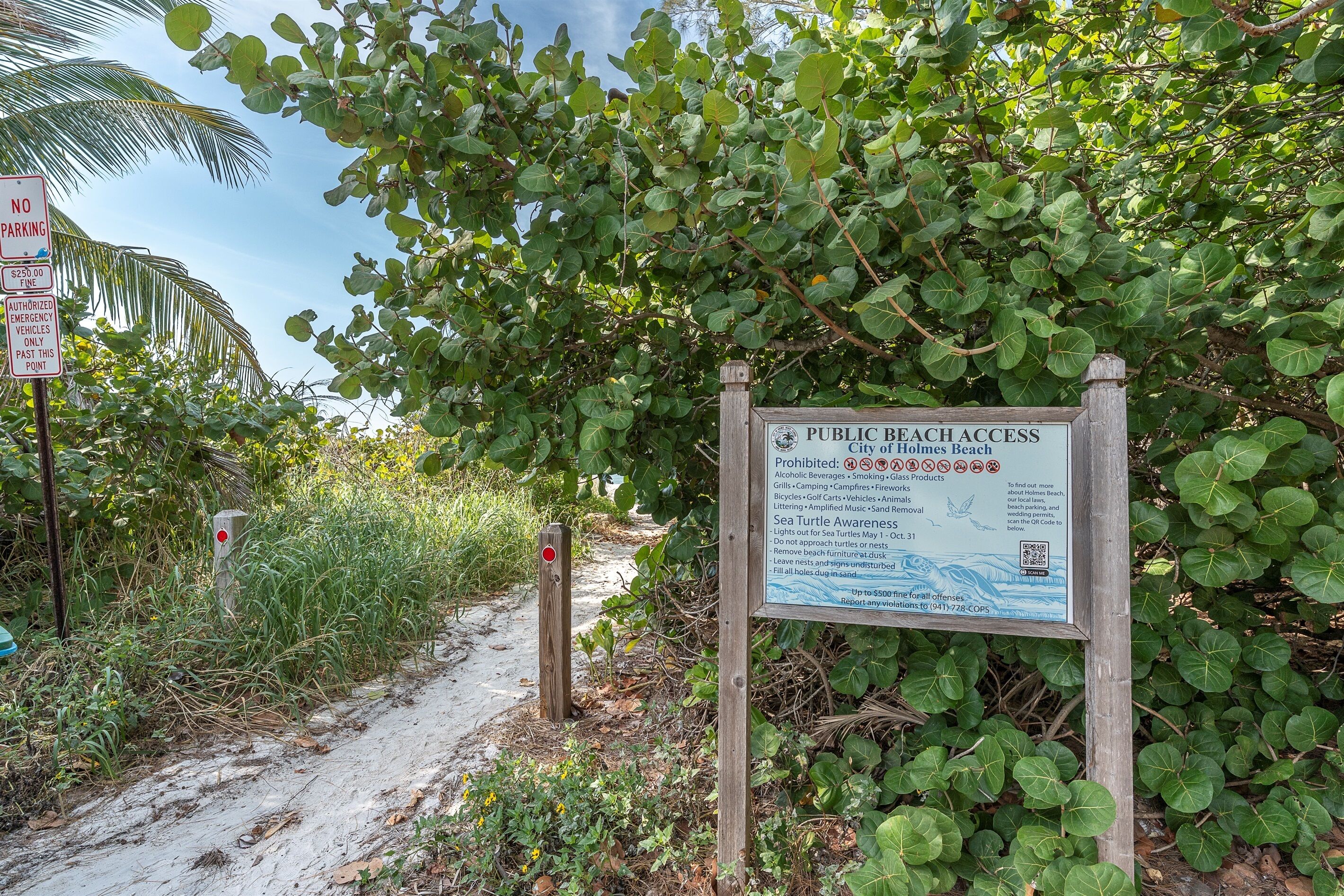 Un panneau indiquant l’accès à la plage, avec une liste des articles dont l’accès est interdit et un code QR pour obtenir de plus amples informations.