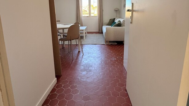 A narrow hallway with a skylight, a dining area with chairs and a table, and a sofa with cushions. - Joli t2 (Marius) (Aubagne)
