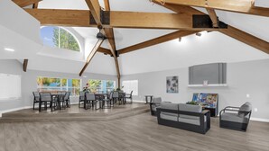 A spacious room with a high ceiling and exposed wooden beams, a dining area with a table and chairs, and a seating area with a sofa and armchairs. - Resort Stay~Near Disney~Bright~Gym~Hot Tub (Kissimmee)