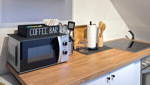 Uma cozinha com um balcão de café, torradeira e bancada de madeira.