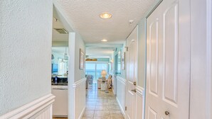 A hallway with a tiled floor, white walls, and a ceiling with recessed lighting. - Ocean Sands 1-501 (Madeira Beach)