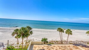 A beach view with palm trees and a clear sky. - Ocean Sands 1-501 (Madeira Beach)