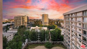 A high-rise building with a modern design, surrounded by other residential buildings and greenery. - Modern Cozy 1-bedroom condo in Beverly Hills (Los Angeles)