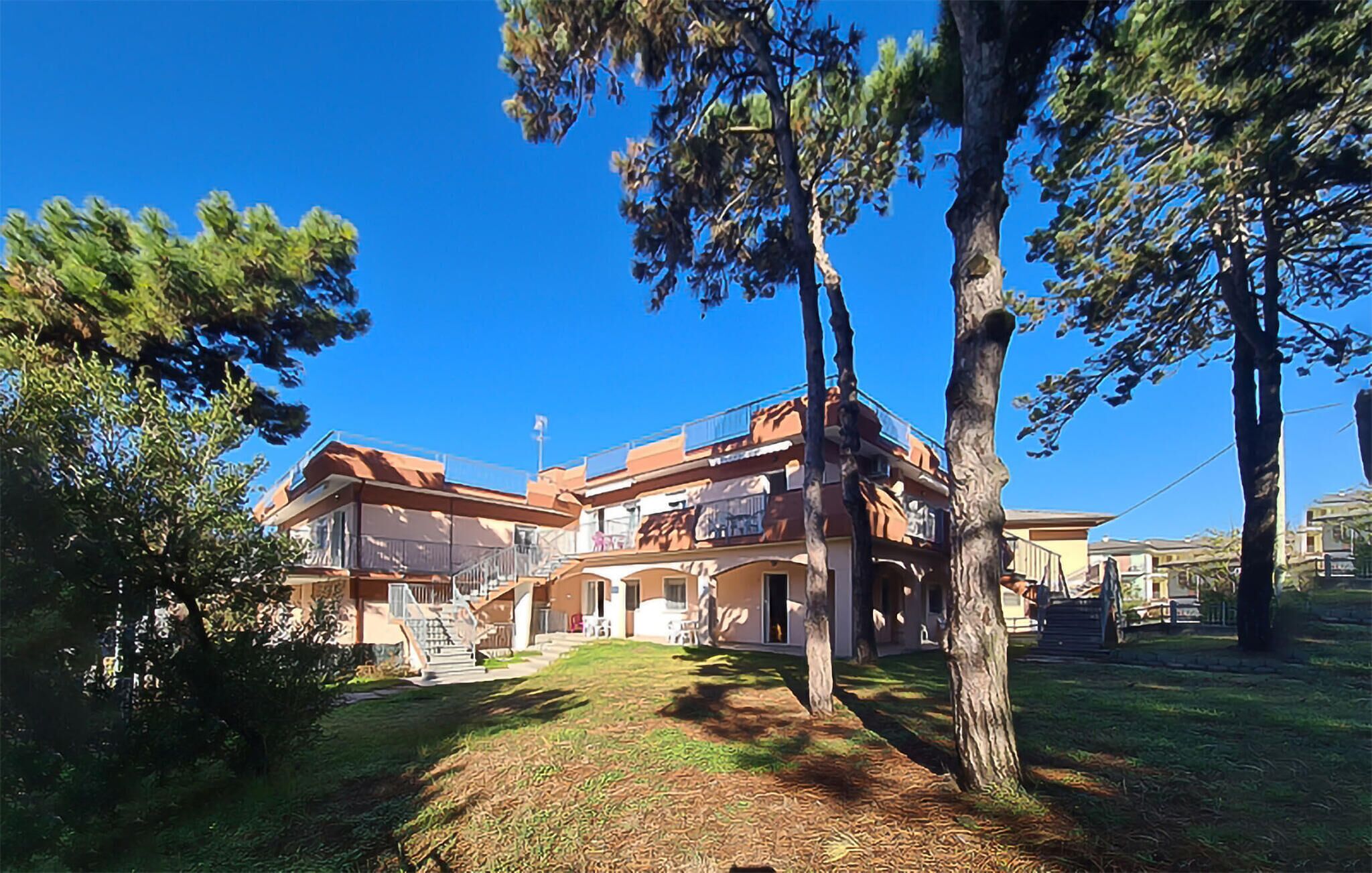 Un edificio a due piani con un balcone e una scalinata che conduce all'ingresso.