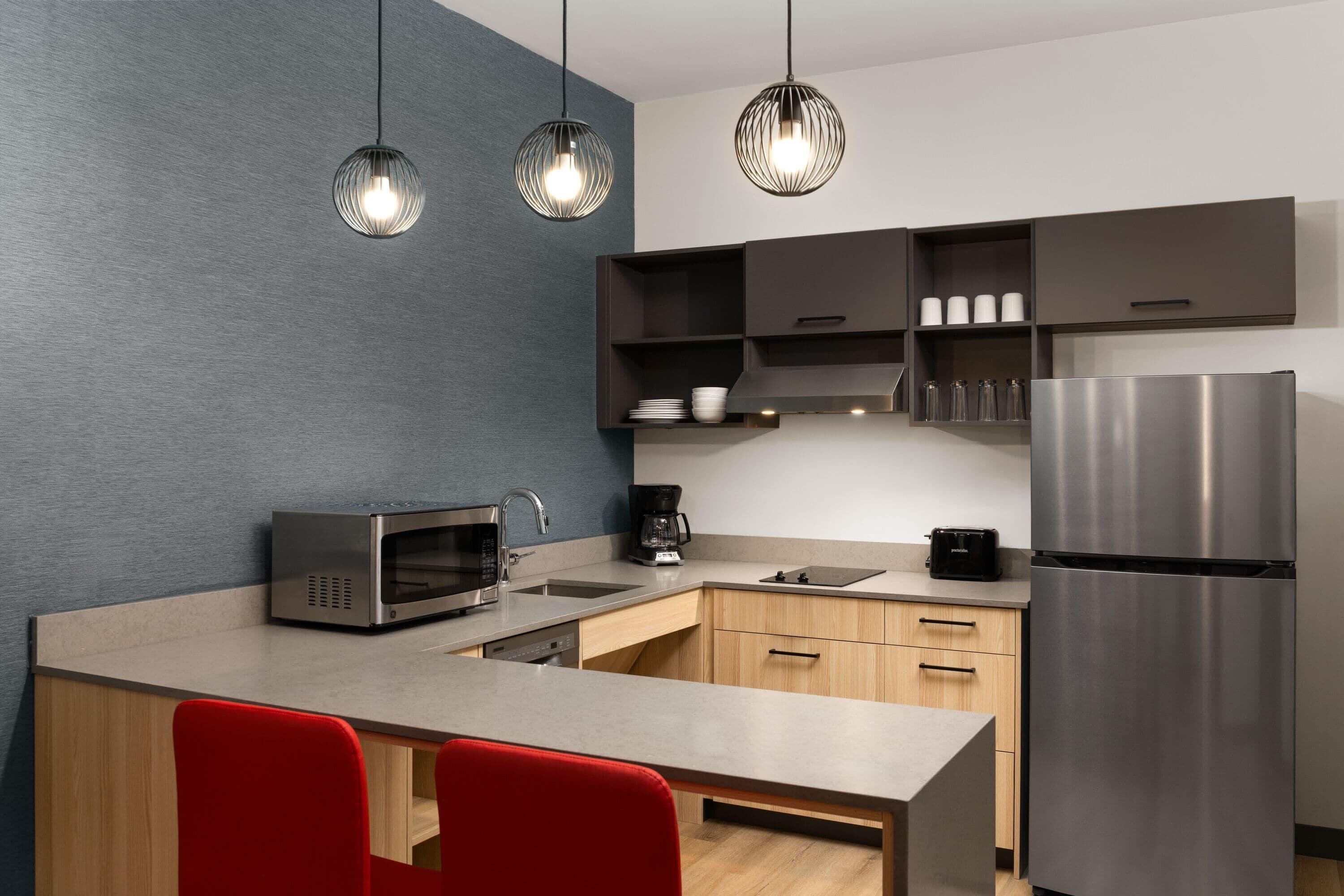 Una cocina moderna con microondas, cafetera y refrigerador de acero inoxidable.