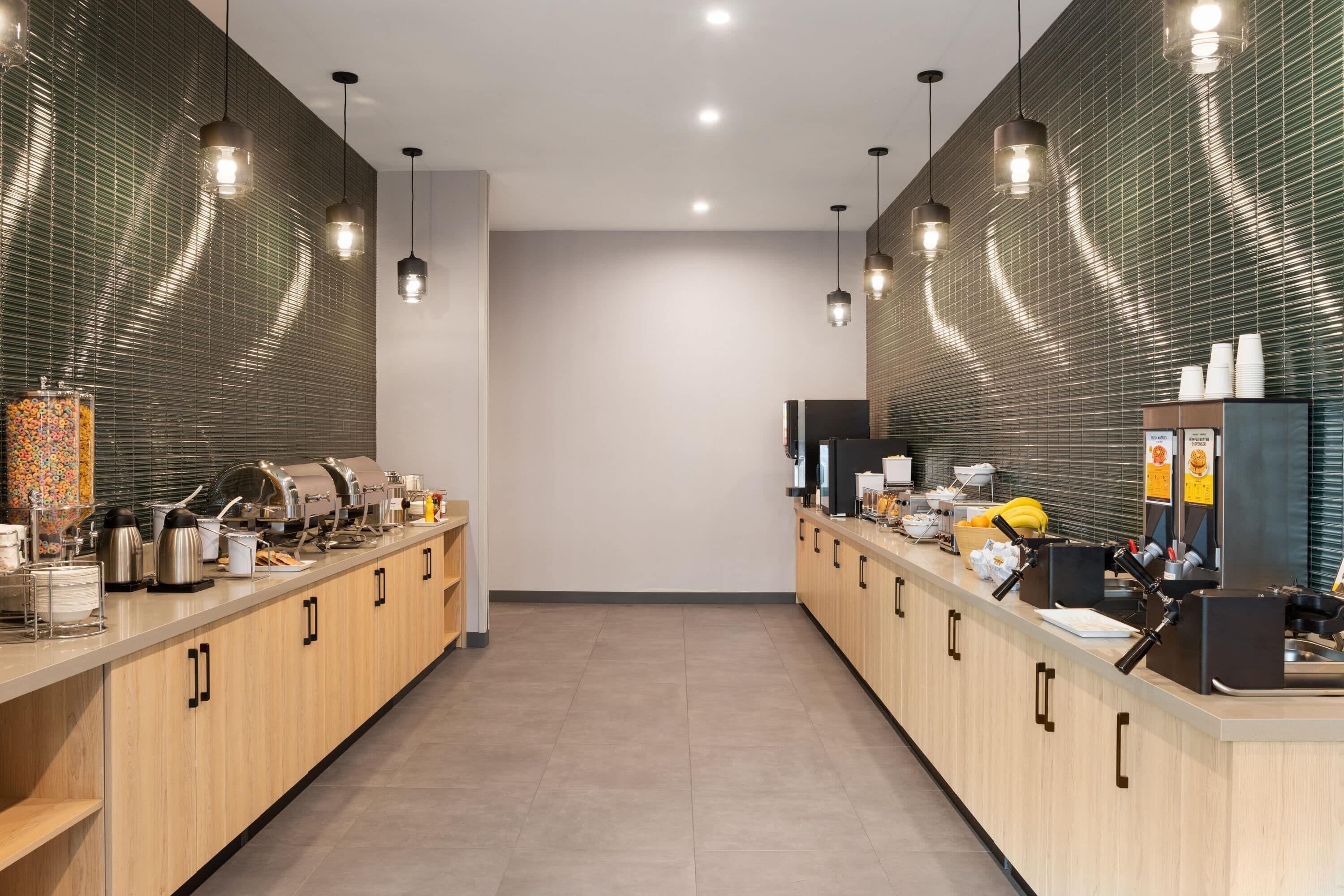 A modern kitchen with stainless steel appliances, wooden cabinets, and pendant lighting.