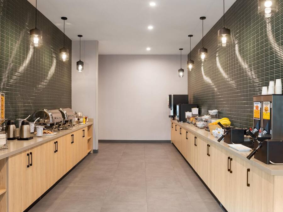 A modern kitchen with stainless steel appliances, wooden cabinets, and pendant lighting.