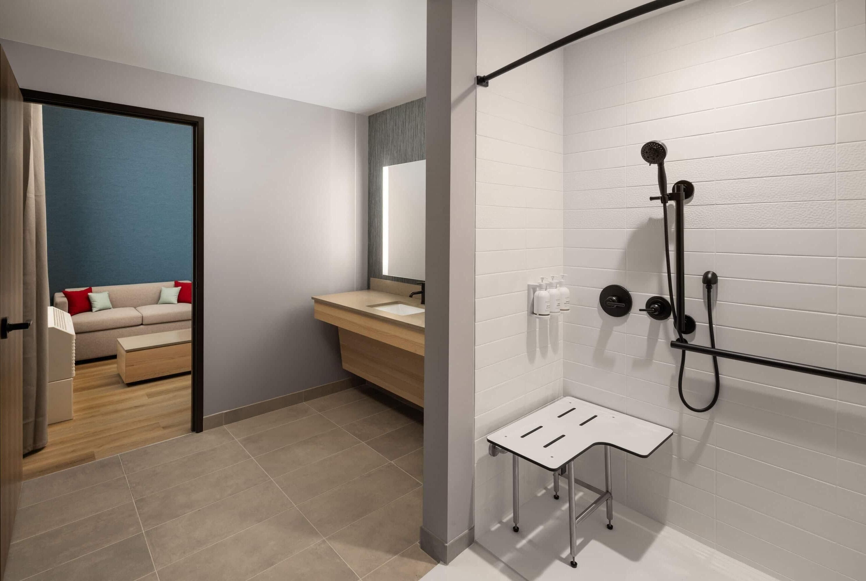 A modern bathroom with a shower, a sink, and a small table.