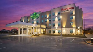 Ein Hotel im modernen Stil, mit einem Schild für Wingate by Wyndham, einem Schild für Hawthorn Extended Stay und einem gut beleuchteten Eingang.