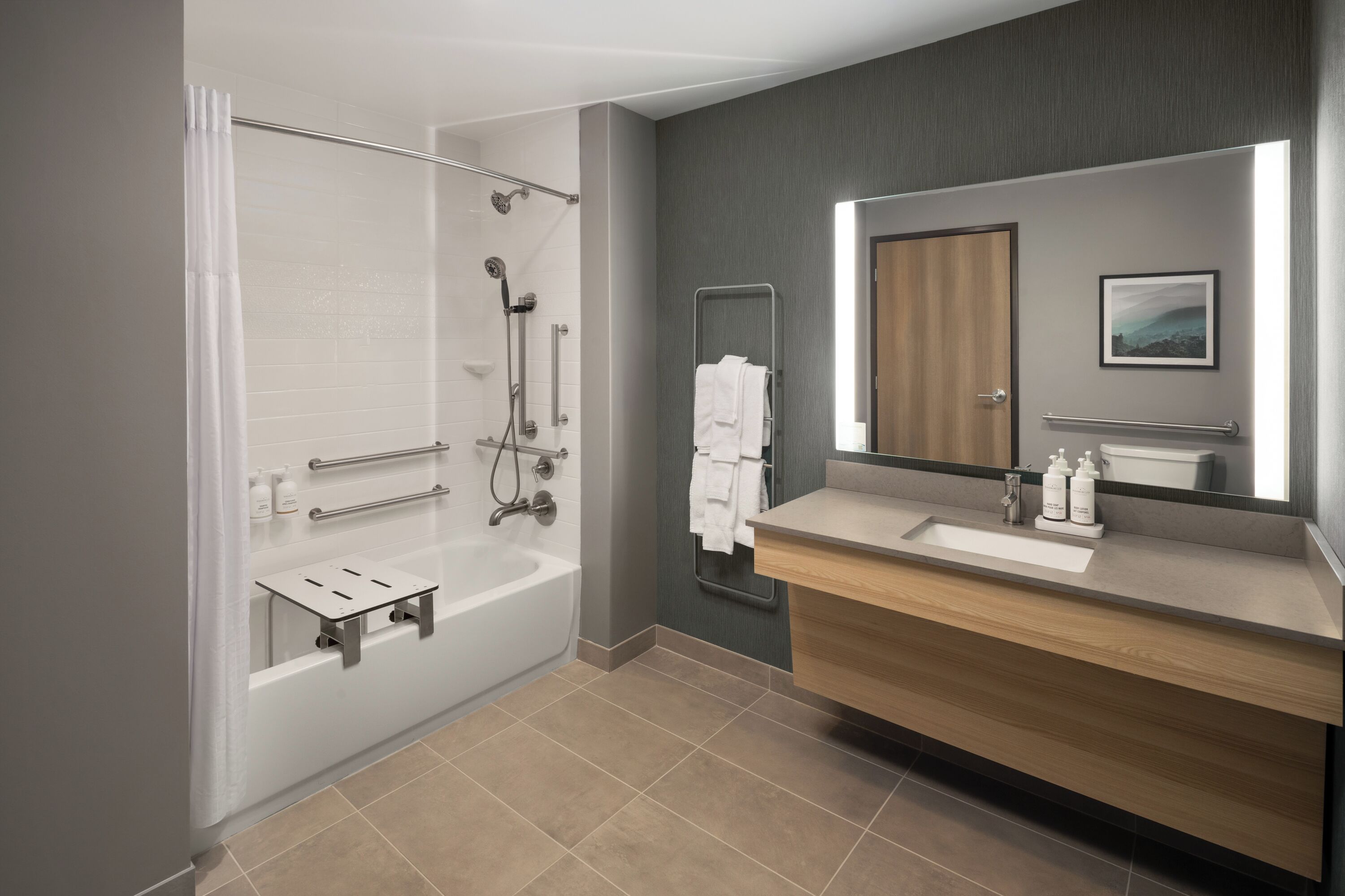 A modern bathroom with a shower, a bathtub, a vanity with a mirror, and a towel rack.