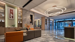 A modern lobby with a reception desk, seating area, and large windows. - Howard Johnson Airport Hotel Changsha (Changsha)