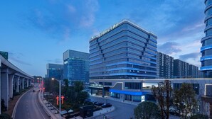 A modern hotel with a curved facade, multiple floors, and a prominent entrance. - Howard Johnson Airport Hotel Changsha (Changsha)