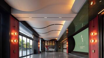 A modern interior with a curved ceiling, red doors, and a wall with a projection.
