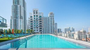 A rooftop pool with a view of high-rise buildings, lounge chairs, and a clear sky. - Cosy 3Beds/3Baths High Floor Unit Heart Of Miami (Miami)