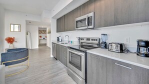 A modern kitchen with grey cabinets, stainless steel appliances, and a white countertop. - Cosy 3Beds/3Baths High Floor Unit Heart Of Miami (Miami)