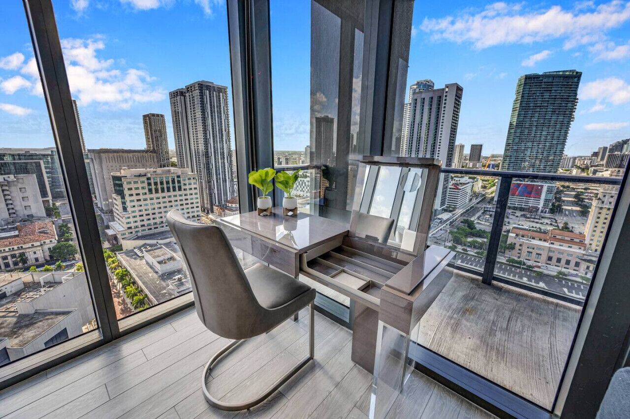 A modern office space with a desk, chair, and potted plants.