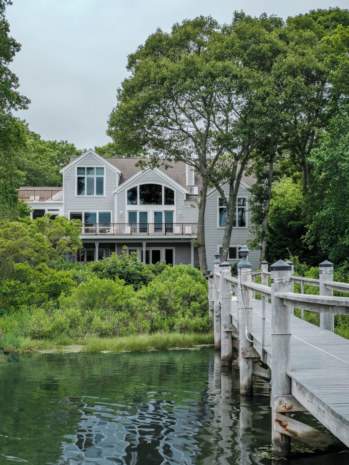 Waterfront backyard with private dock and a stunning view of the home.