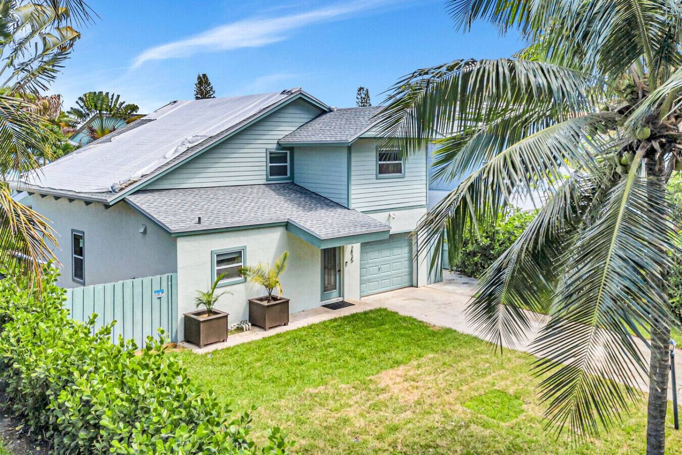 A two-story house with a sloped roof, a front garage, and a well-maintained lawn.