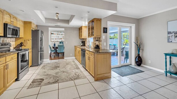 Een moderne keuken met houten kastjes, roestvrijstalen apparatuur en een groot eiland.
