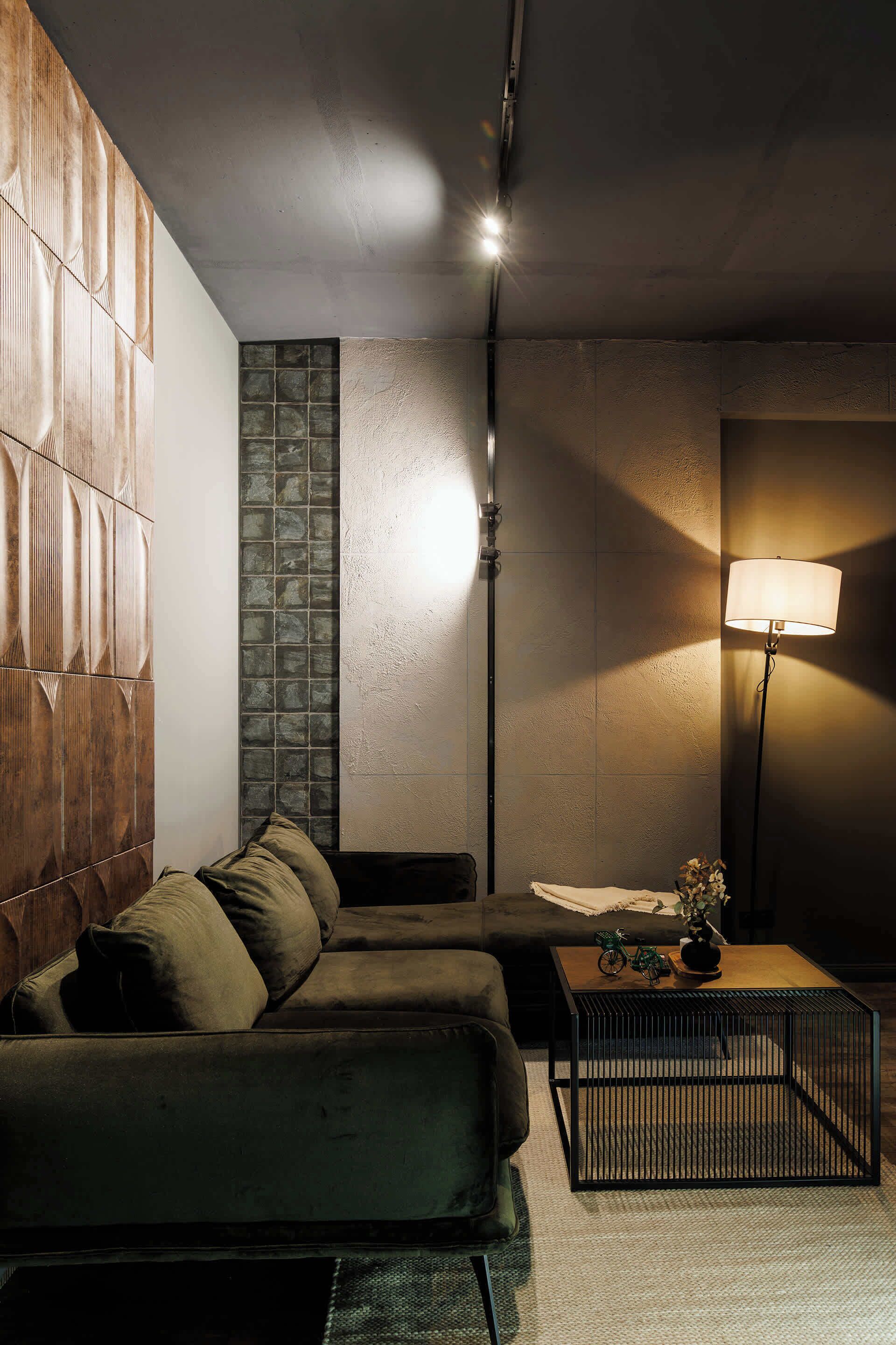 A modern room with a sectional sofa, a coffee table, and a lamp.