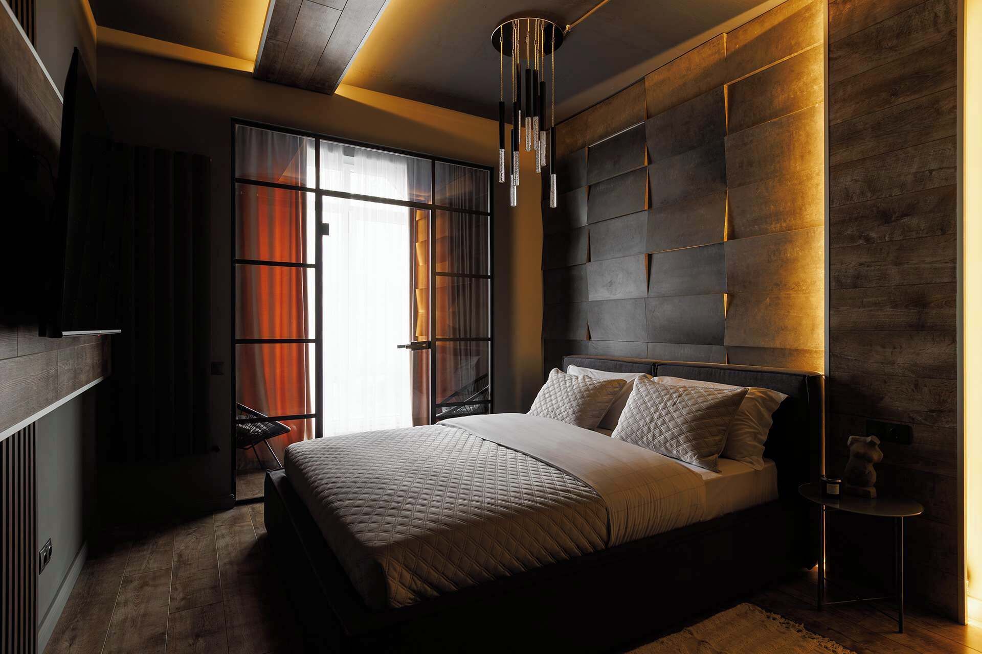 A modern bedroom with a large bed, a built-in headboard, and a skylight.