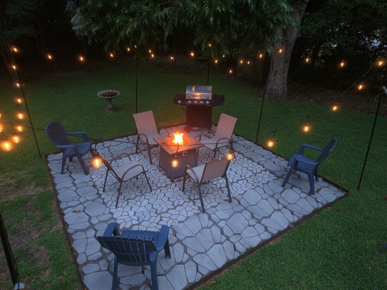 A patio with stone flooring, a fire pit, and outdoor seating.