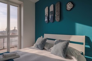 A bedroom with a bed, two pillows, a window, and three wall-mounted items. - Suite in two-room apartment in downtown Bergamo [BGY-10 Airport]] (Bergamo)