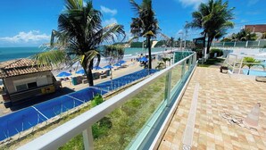 A beachside view with a pool, palm trees, and a clear sky. - Ponta Negra Beach (Natal)