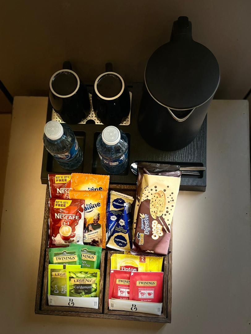 A coffee station with two coffee makers, two water bottles, and a variety of coffee and tea products.