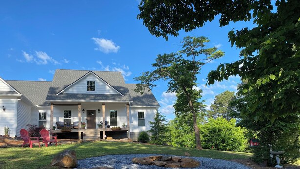 A two-story house with a covered porch, a stone patio, and a well-maintained lawn. - 3-bedroom home on quiet road with horse farms (Canton)
