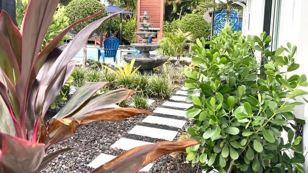 A garden with a stone pathway, a fountain, and various plants. - The Villa unit - The Agustin Guesthouse for Men, a beautiful & sexy resort oasis (Fort Lauderdale)