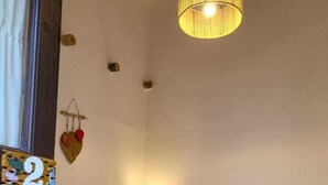 Une chambre confortable avec un lit, des tables de chevet, une lampe et un luminaire suspendu.