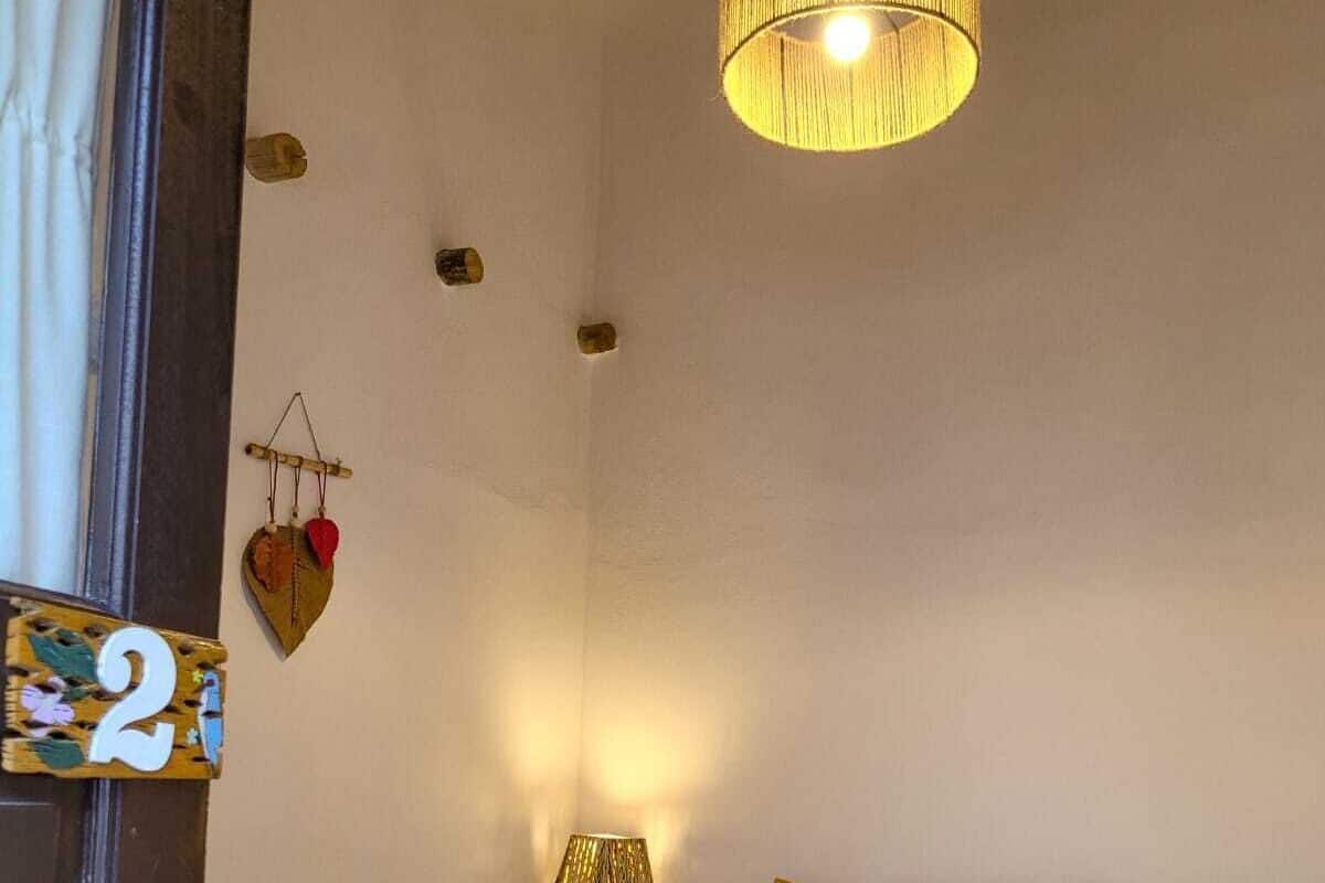 Un dormitorio acogedor con cama, mesitas de noche, lámpara y una lámpara colgante.
