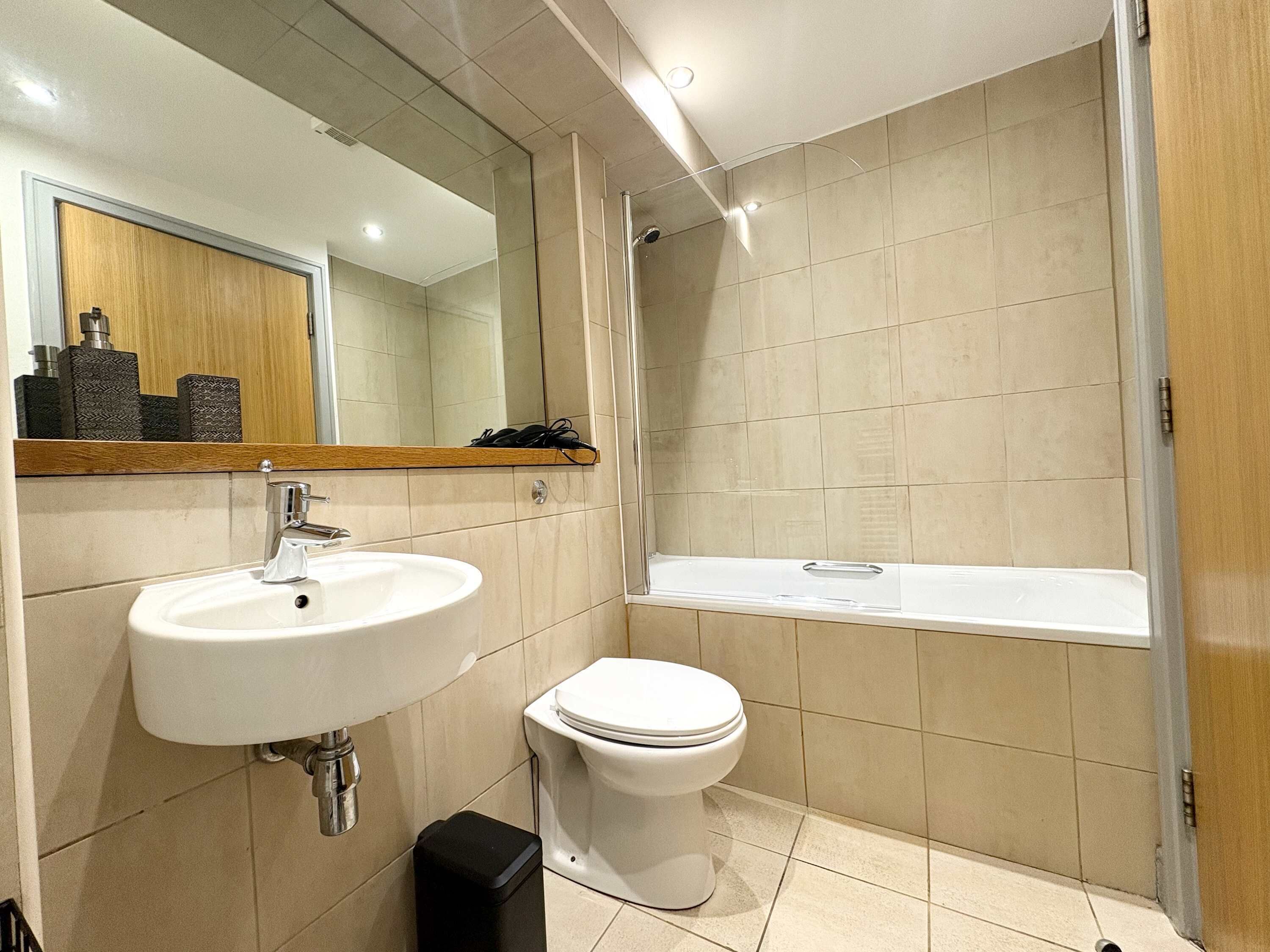 A modern bathroom with a sink, toilet, and shower.
