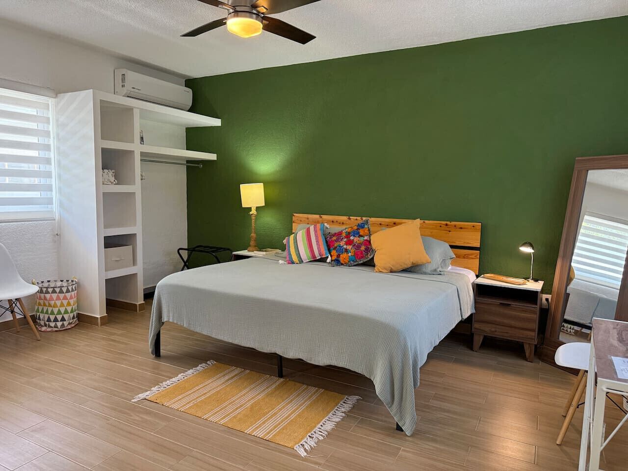 Une chambre à coucher comprenant un lit, des tables de chevet, une armoire, un bureau et une chaise.